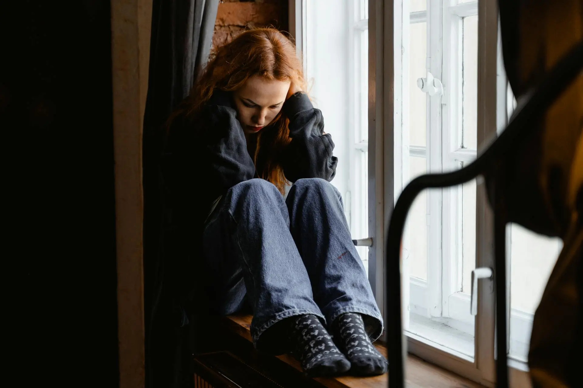 Depressed-Woman-Sitting-by-the-Window.webp
